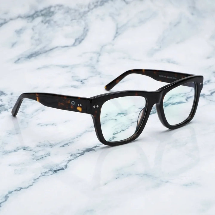 Lentes ópticos Barcelona 1 Carey sobre mármol blanco elegante armazón premium Bonoboss #editorial_armazon #color_carey