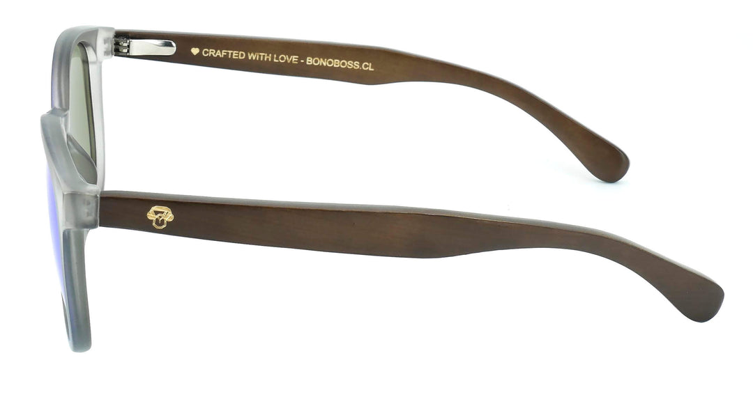 anteojos redondos de plástico reciclado y varillas de madera natural sustentable con lentes de color espejado azul. Polarizadas y forma redonda. La gafa es color transparente