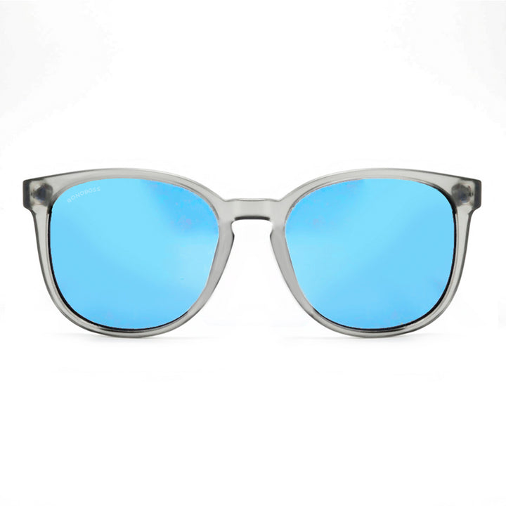 anteojos redondos de plástico reciclado y varillas de madera natural sustentable con lentes de color espejado azul. Polarizadas y forma redonda. La gafa es color transparente #color_espejado-azul