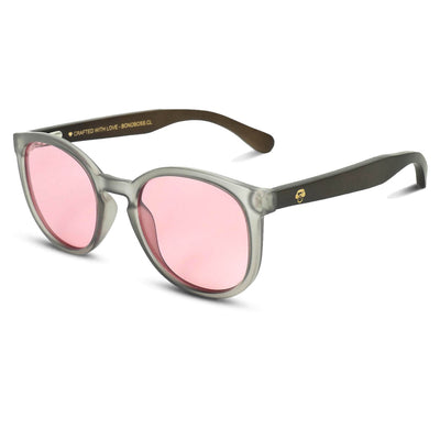 anteojos redondos de plástico reciclado y varillas de madera natural sustentable con lentes de color rosado. Polarizadas y forma redonda. La gafa es color transparente