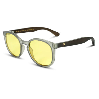 anteojos redondos de plástico reciclado y varillas de madera natural sustentable con lentes de color amarillo. Polarizadas y forma redonda. La gafa es color transparente