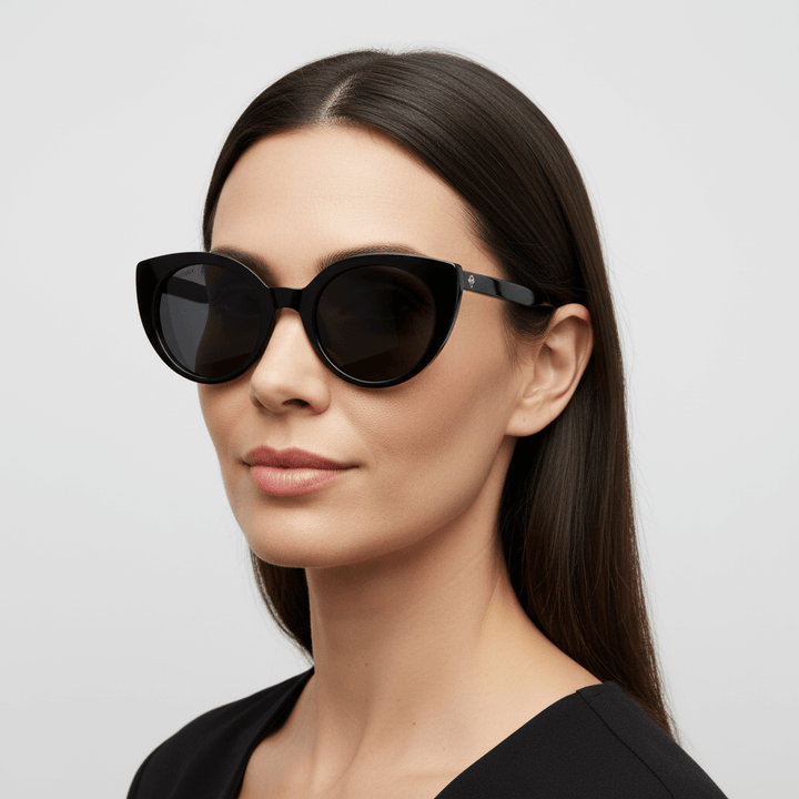 vista lateral de una mujer de pelo liso castaño usando anteojos de sol gafa polarizada de forma agatada retro para hombre y mujer de cara redonda grande #color_negro