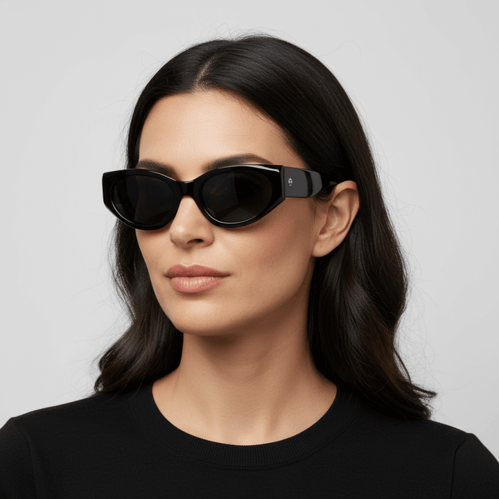 la vista lateral de una mujer de cara redonda con pelo ondulado suelto de color castaño oscuro mirando hacia arriba en 45º usando unos anteojos de sol polarizados Bonoboss sustentables ecologicos en acetato reciclado de color negro y lentes de color negro con receta #color_negro