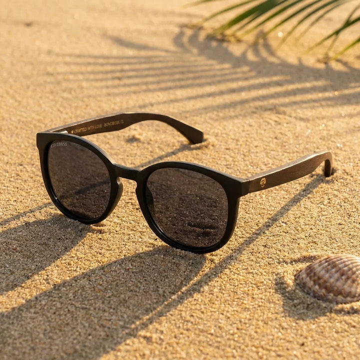 Lentes sol Meli Dark polarizados UV400 sobre arena dorada costa textura natural Bonoboss #color_negro