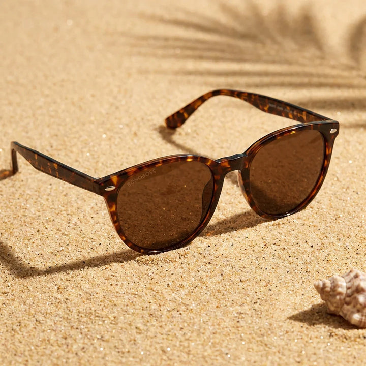 Lentes sol Henua polarizados UV400 sobre arena dorada costa textura natural Bonoboss #color_carey
