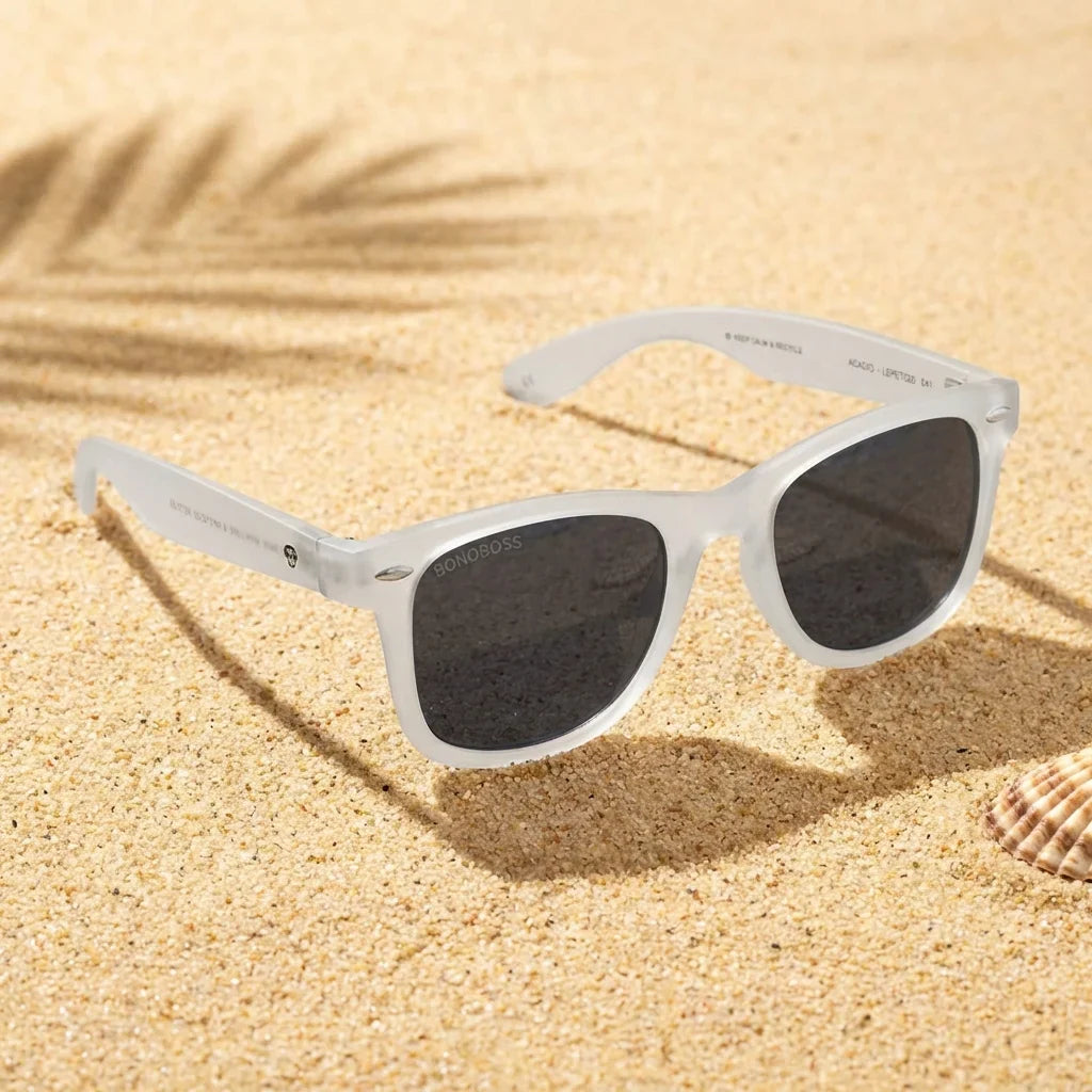 Lentes sol Acacio RPET polarizados UV400 sobre arena dorada costa textura natural Bonoboss #color_transparente