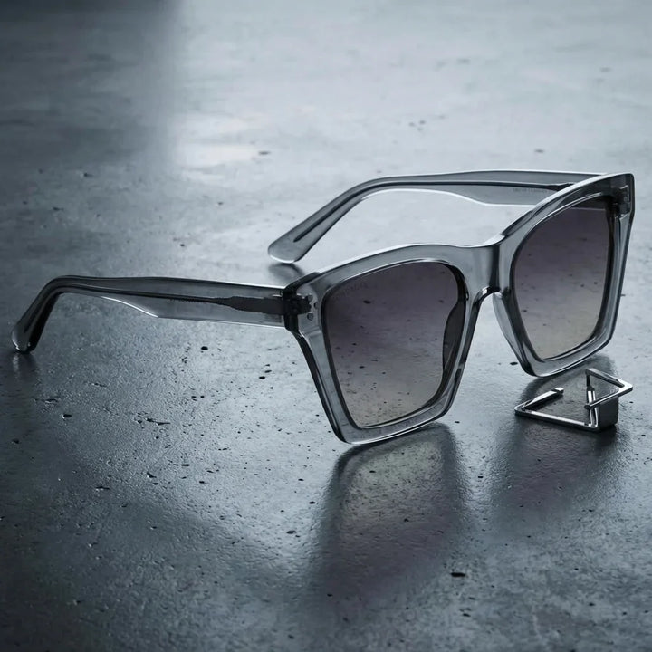 Lentes sol Bruna polarizados UV400 sobre concreto urbano textura industrial Bonoboss #color_transparente