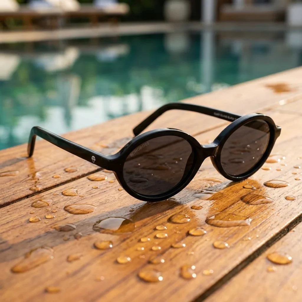 Lentes sol Guapi Island polarizados UV400 sobre madera teca con agua fresca Bonoboss #color_negro