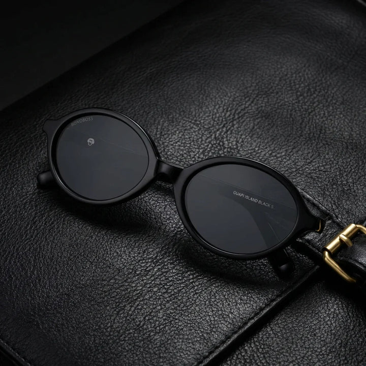 Lentes sol Guapi Island polarizados UV400 bio-acetato negro sobre cuero negro detalle brass premium contraste Bonoboss #editorial_grid1 #color_negro