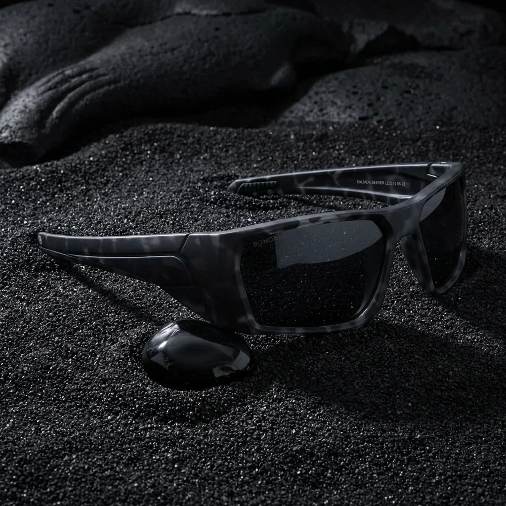 Lentes sol Salmon Seeker polarizados UV400 sobre arena negra volcanica Bonoboss #color_dark-camo