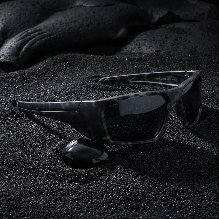 Lentes sol Salmon Seeker polarizados UV400 sobre arena negra volcanica Bonoboss #color_dark-camo