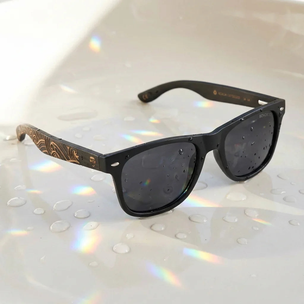 Lentes sol Acacia Dark Designer's polarizados UV400 sobre superficie con agua y luz natural Bonoboss #color_smoke