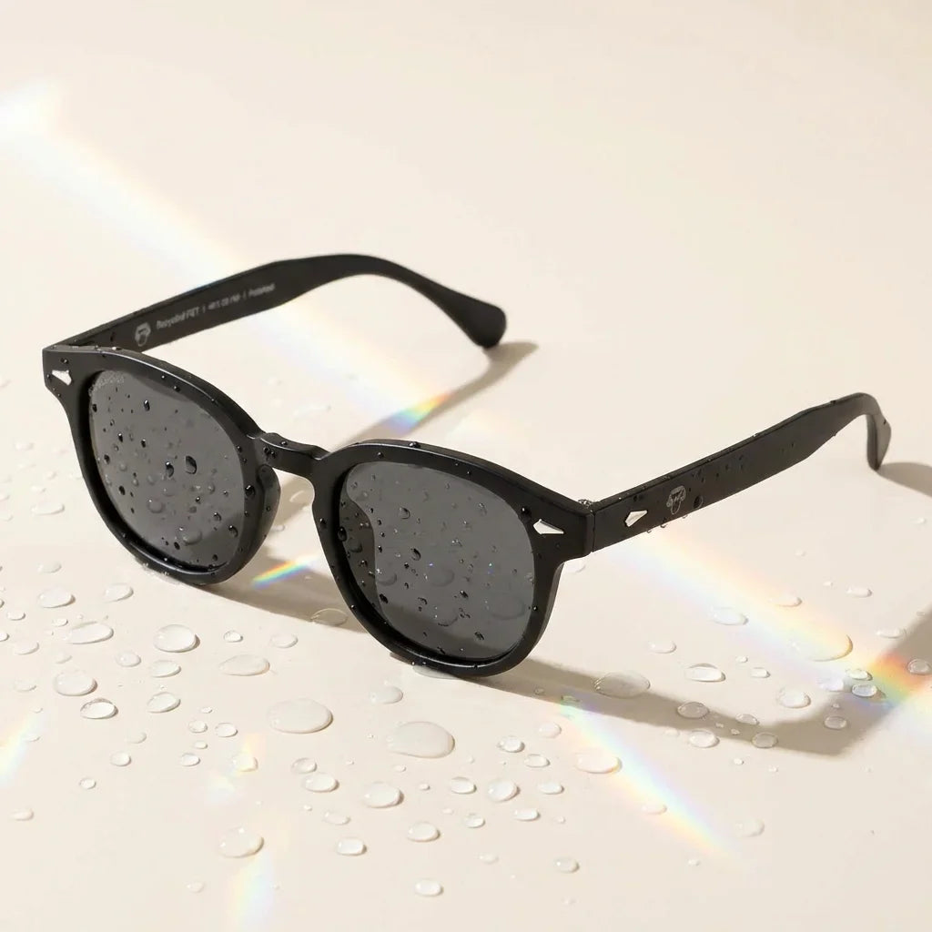 Lentes sol Waimea RPET polarizados UV400 sobre superficie con agua y luz natural Bonoboss #color_negro