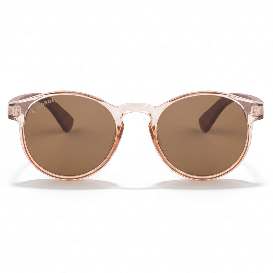 la vista frontal de unos anteojos anteojos gafas de sol polarizadas de forma redonda y con puente para narices anchas hechas de plastico reciclado sustentable ecologico personalizada y patas de madera de #color_rosa