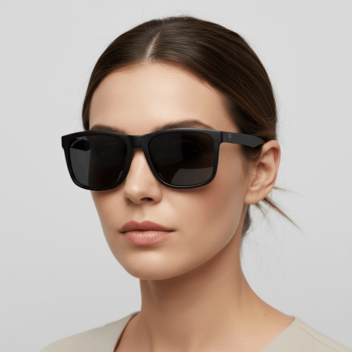 la vista lateral de una mujer usando anteojos gafas de sol polarizadas de plastico reciclado con lentes de color negras y marco de #color_dark