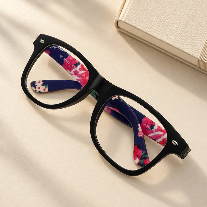 Lentes de lectura Acacia Negro filtro luz azul bodegón vista cenital sobre superficie crema con libro Bonoboss #editorial_banner #color_default