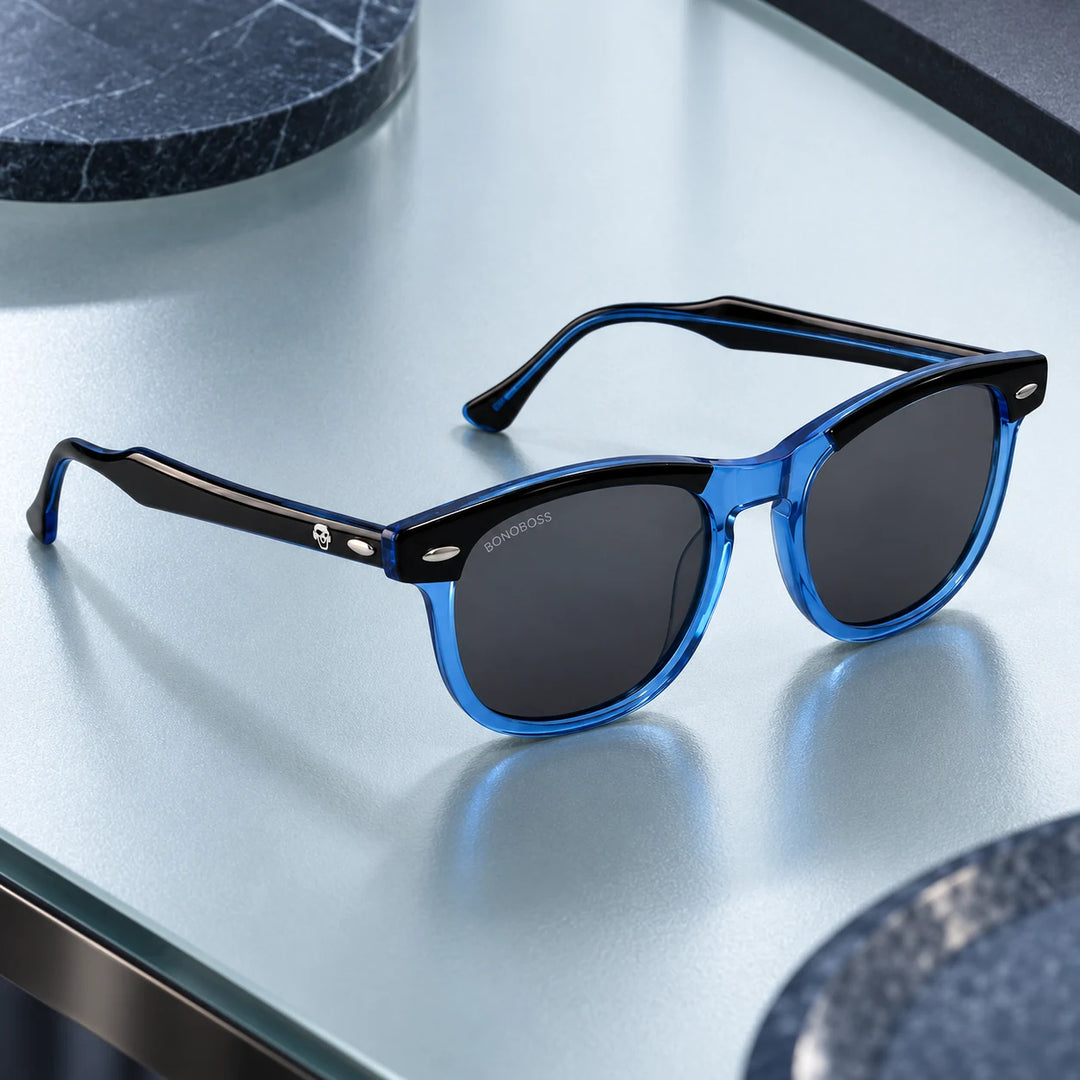 Lentes de sol polarizados Algarrobo Azul lente Gris bodegón sobre mesa de vidrio azul Bonoboss #editorial_banner #color_azul
