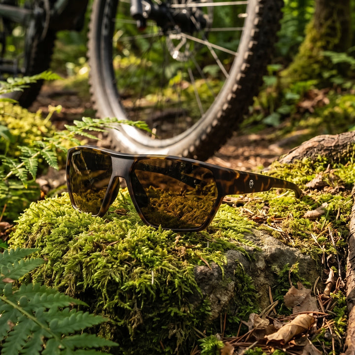 Bonoboss Andes Carey lentes de sol deportivos cristal café, detalle sobre roca con musgo #color_carey
