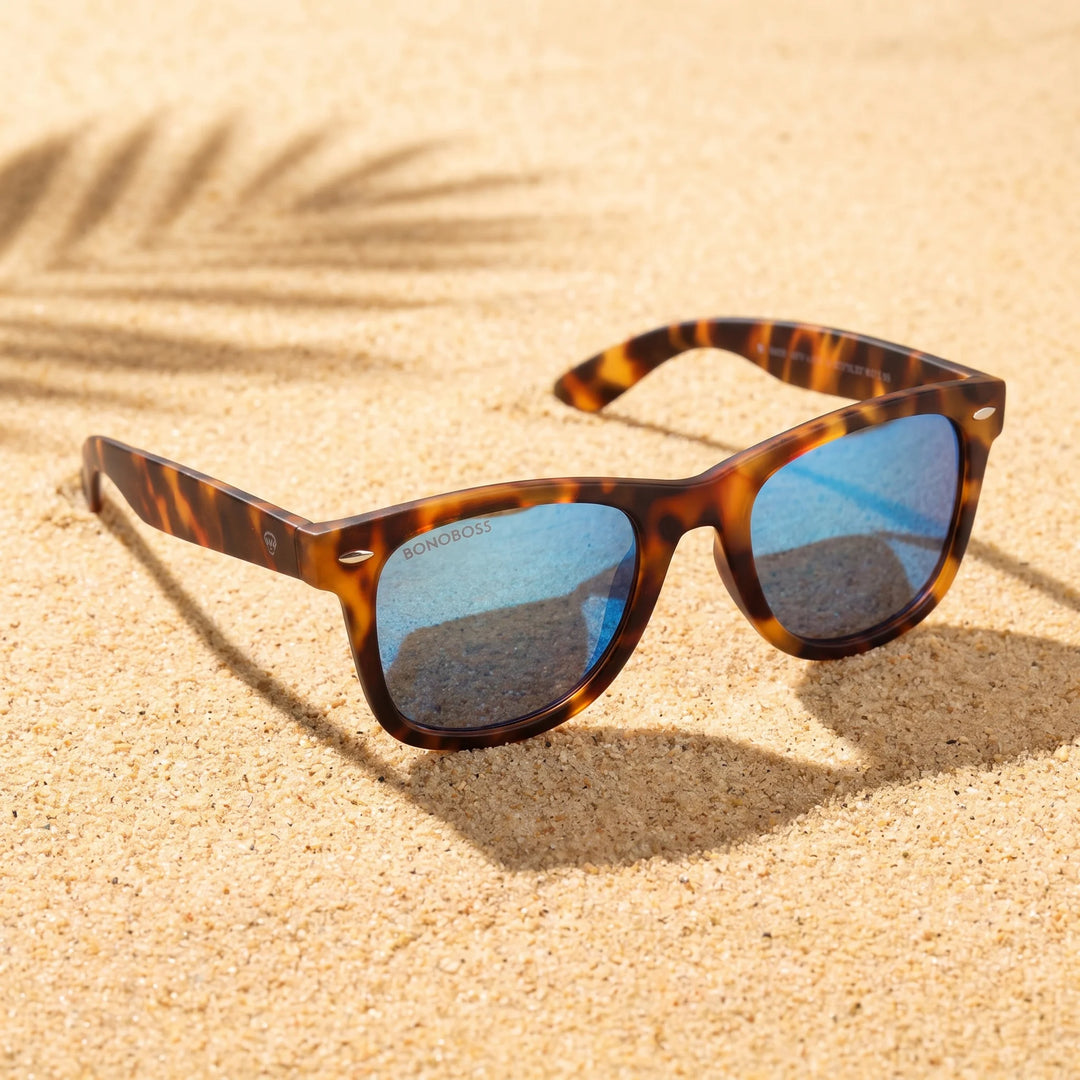Lentes sol Acacia RPET Carey polarizados UV400 sobre arena dorada costa textura natural Bonoboss #color_espejado-azul