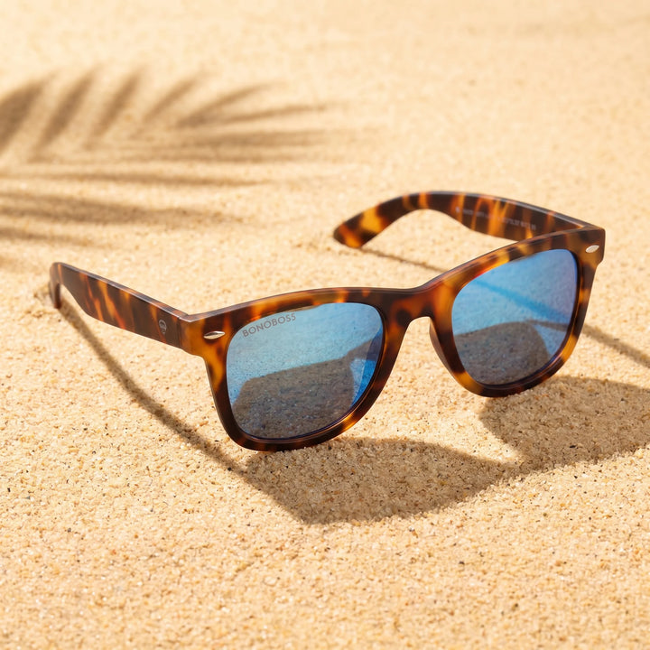 Lentes sol Acacia RPET Carey polarizados UV400 sobre arena dorada costa textura natural Bonoboss #color_espejado-azul