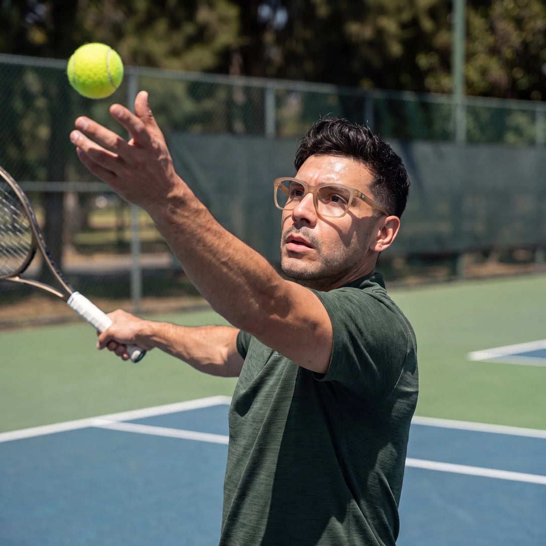 Lentes ópticos deportivos Bonoboss Comaneci Champagne, hombre practicando tenis al aire libre con el armazón puesto #editorial_modelo1 #color_champagne