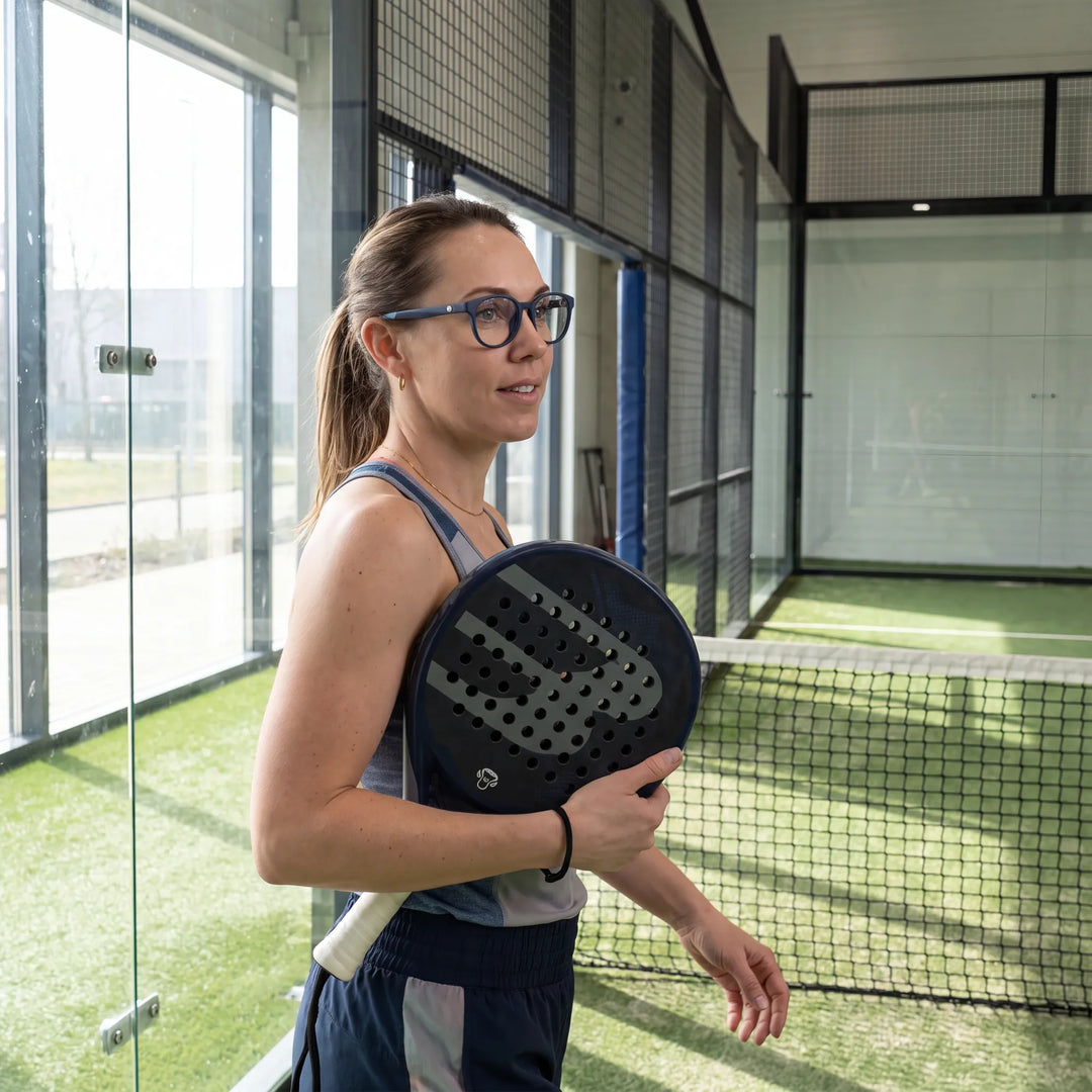 Lentes ópticos deportivos Bonoboss Simone Azul, mujer practicando pádel al aire libre con el armazón puesto #editorial_modelo6 #color_azul