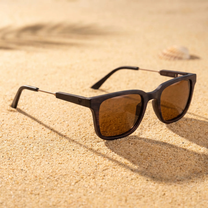 Lentes sol Thanos Ébano Natural UV400 sobre arena dorada costa textura natural Bonoboss #color_brown