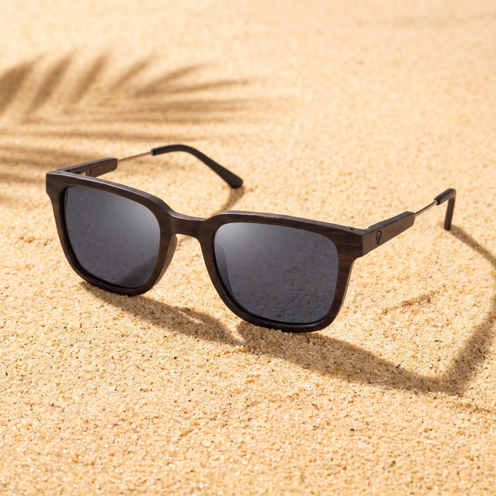 Lentes sol Thanos Ébano Natural UV400 sobre arena dorada costa textura natural Bonoboss #color_negro