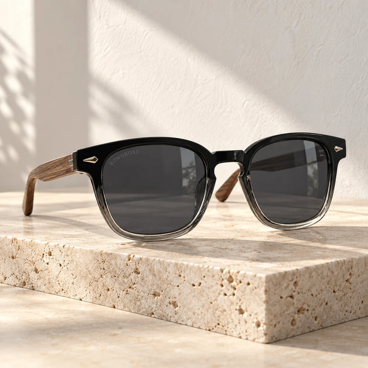 Lentes de sol Bonoboss Creta Negro sobre mesa de mármol en terraza de café #editorial_grid1 #color_negro
