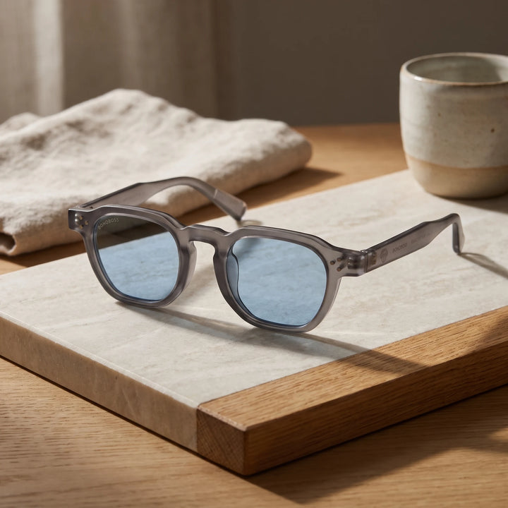 Lentes de sol Bonoboss Damero Blue sobre piedra y roble con luz de ventana #editorial_sustentabilidad #color_blue