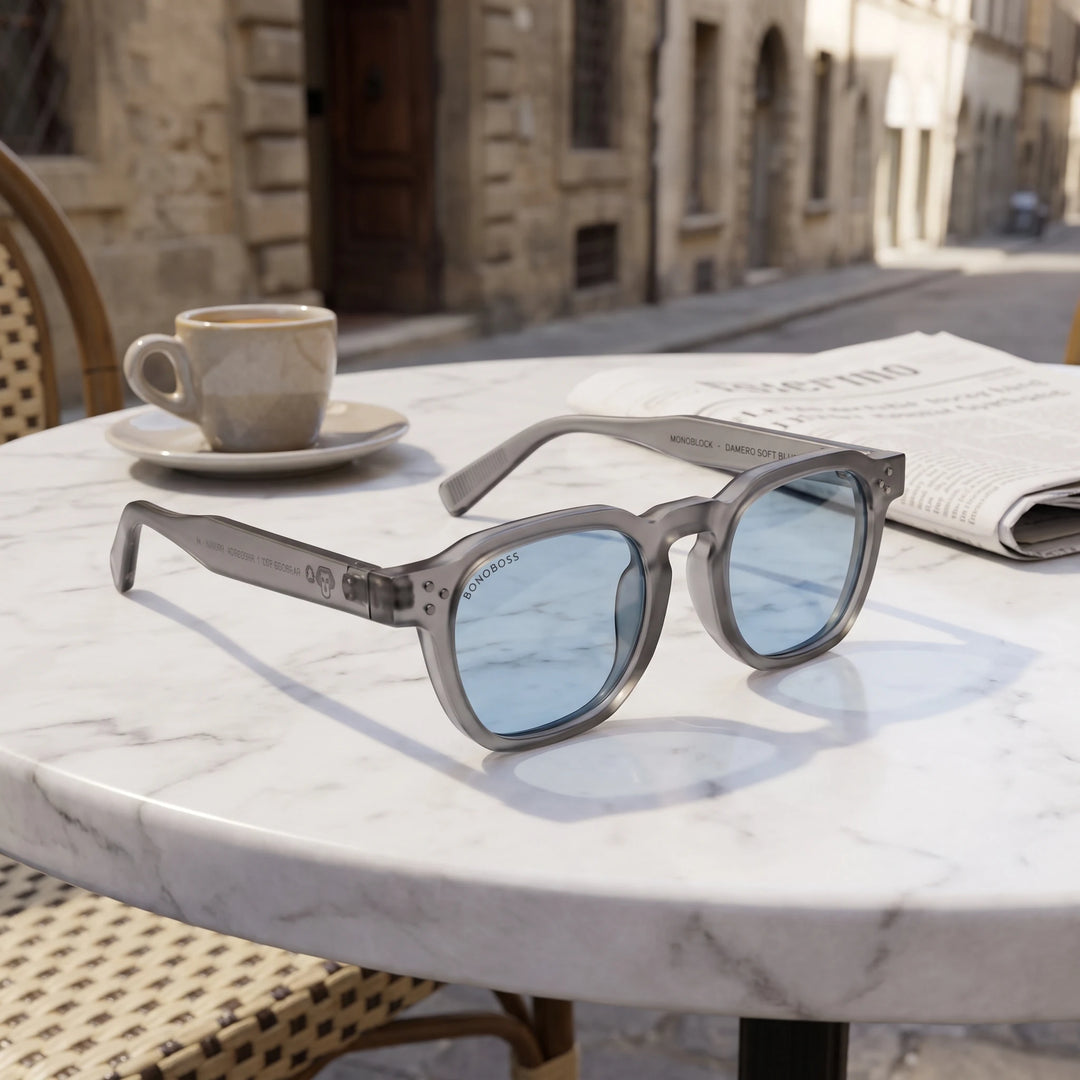 Lentes de sol Bonoboss Damero Blue sobre mesa de mármol en terraza de café #editorial_grid1 #color_blue