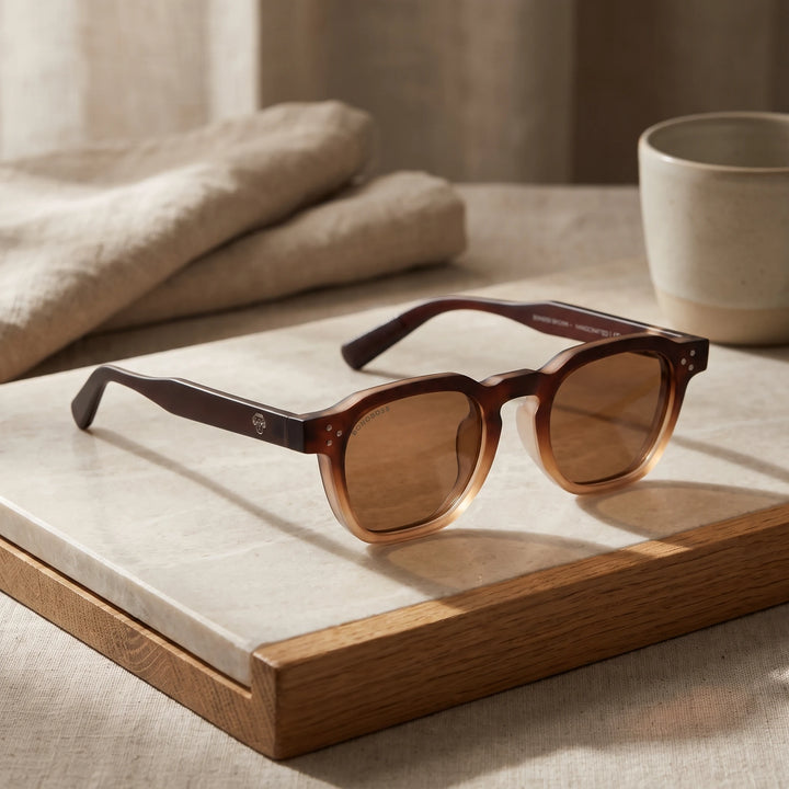 Lentes de sol Bonoboss Damero Brown sobre piedra y roble con luz de ventana #editorial_sustentabilidad #color_brown