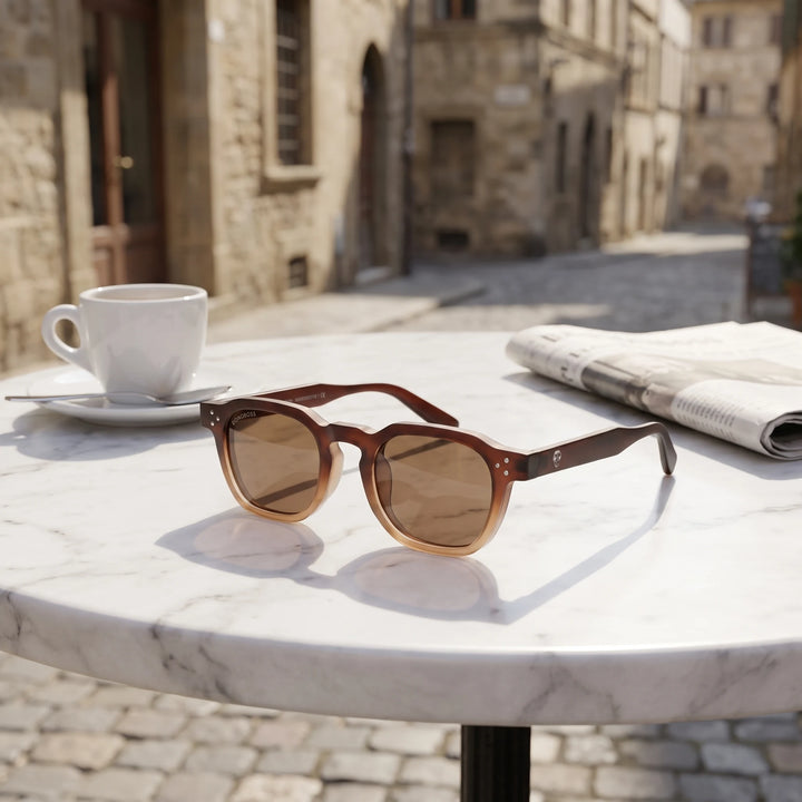 Lentes de sol Bonoboss Damero Brown sobre mesa de mármol en terraza de café #editorial_grid1 #color_brown