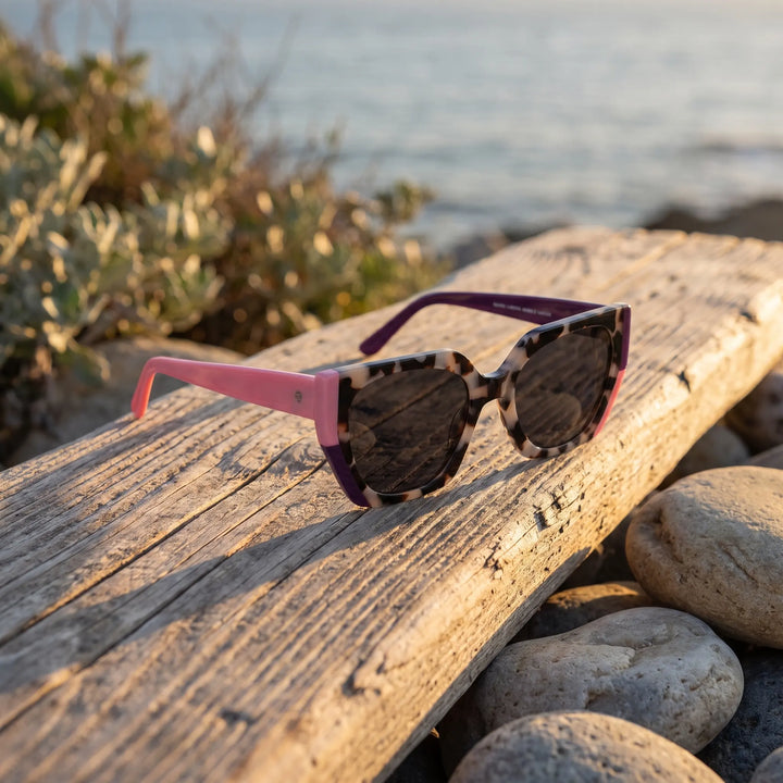 Lentes de sol Bonoboss Di Trevi Marble sobre madera y rocas junto al mar al atardecer #editorial_grid2 #color_marble