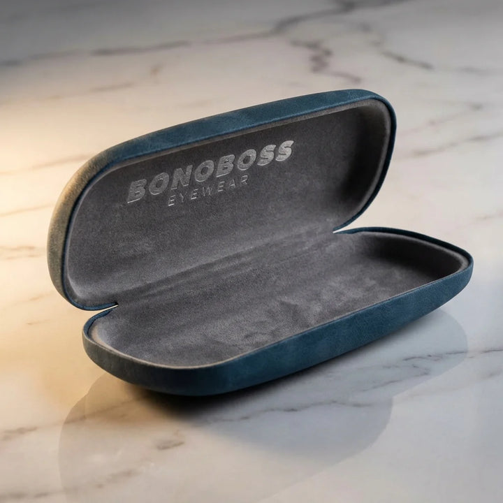Estuche almeja para lentes azul abierto sobre mármol Bonoboss #color_azul