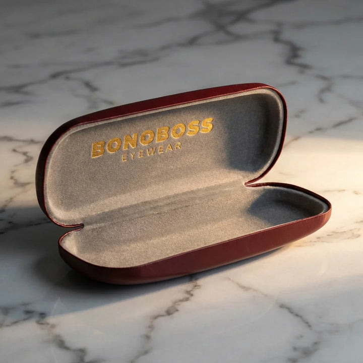 Estuche almeja para lentes burdeo abierto sobre mármol Bonoboss #color_burdeo