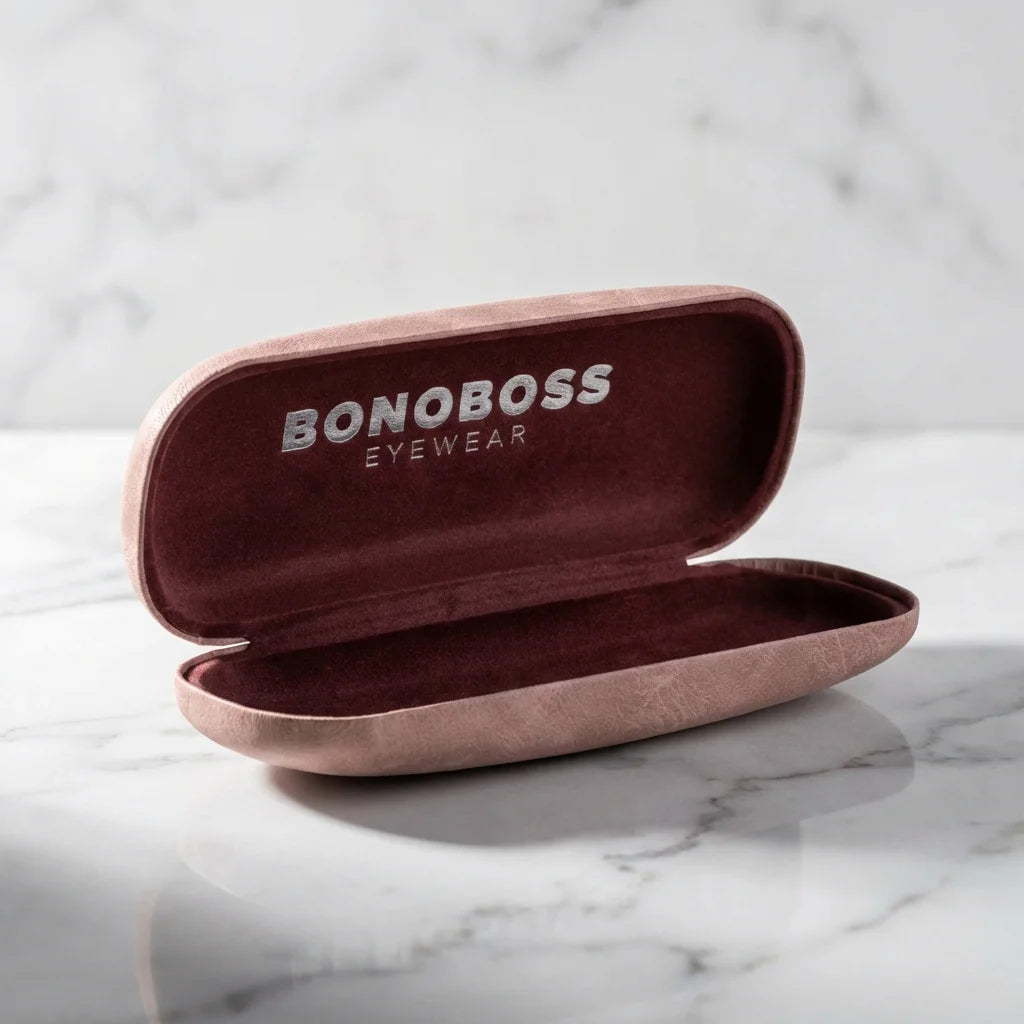 Estuche almeja para lentes rosado abierto sobre mármol Bonoboss #color_rosado