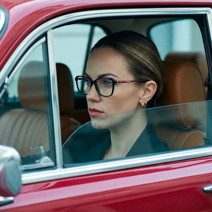 Anteojos Fiore 1006 en negro, en modelo – retrato de campaña, mirada a través de la ventana de un auto clásico rojo