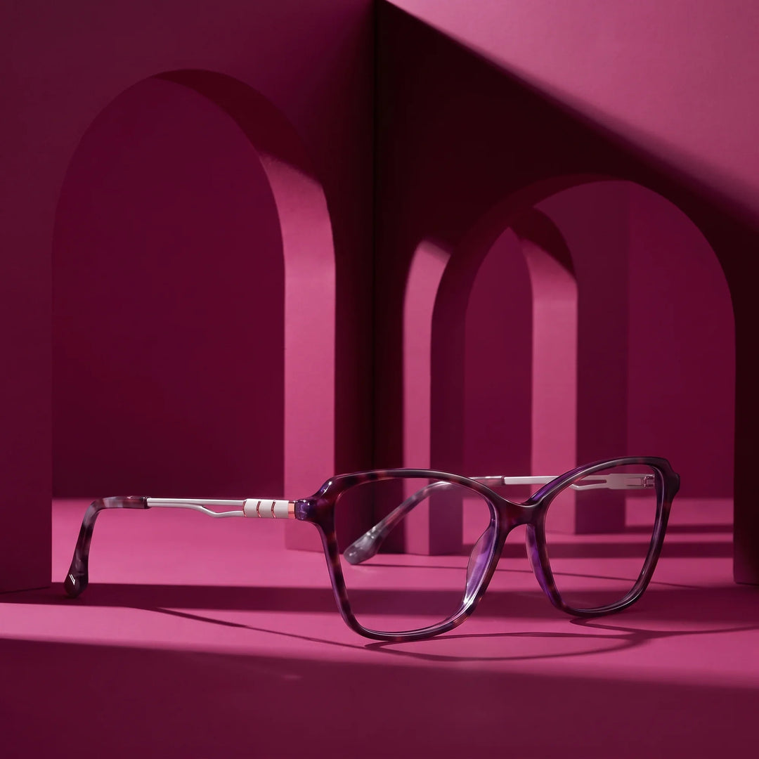 Anteojos Fiore 1006 en morado – displayed on a magenta podium among arches