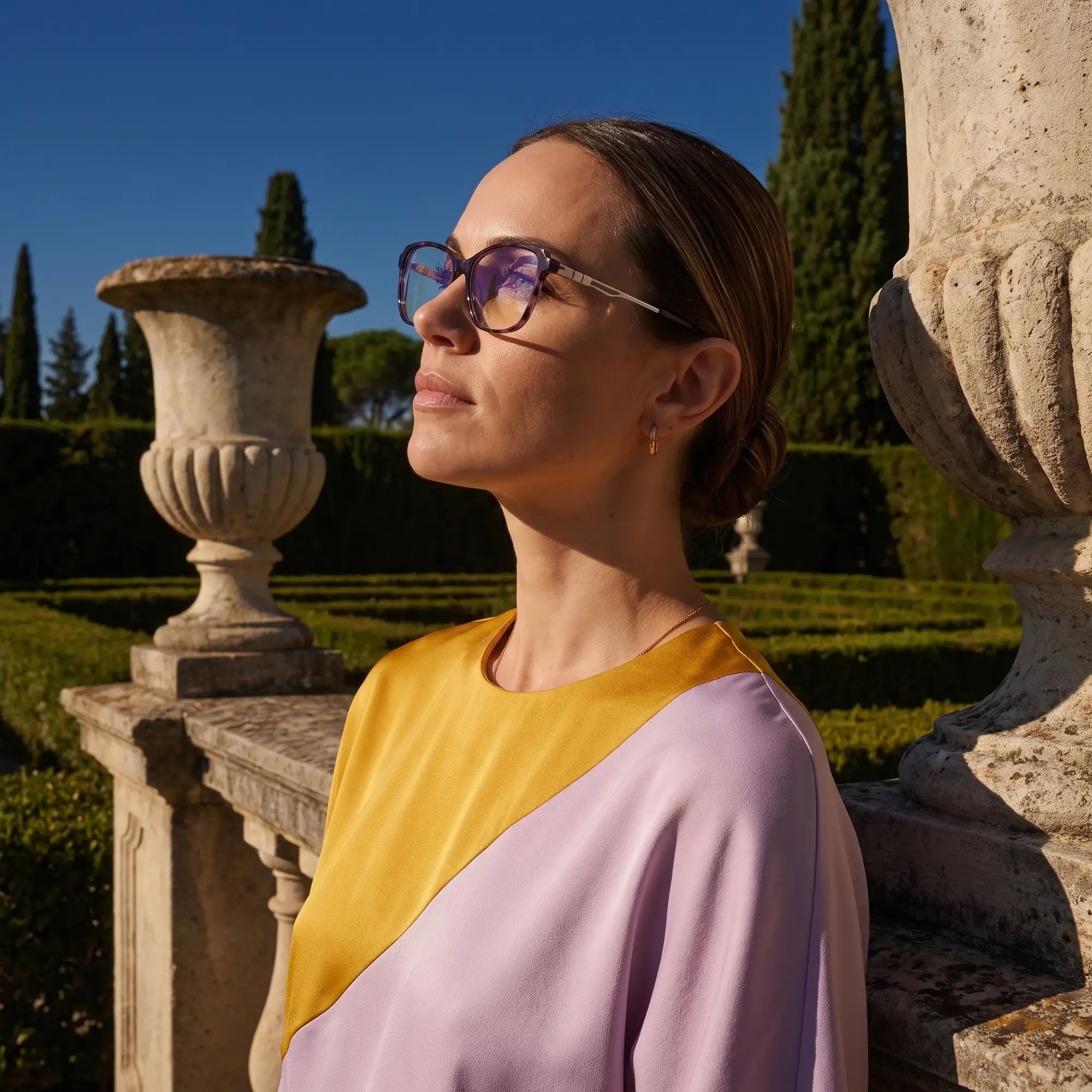 Anteojos Fiore 1006 en morado, en modelo – retrato de campaña, luz de atardecer sobre un jardín de cipreses
