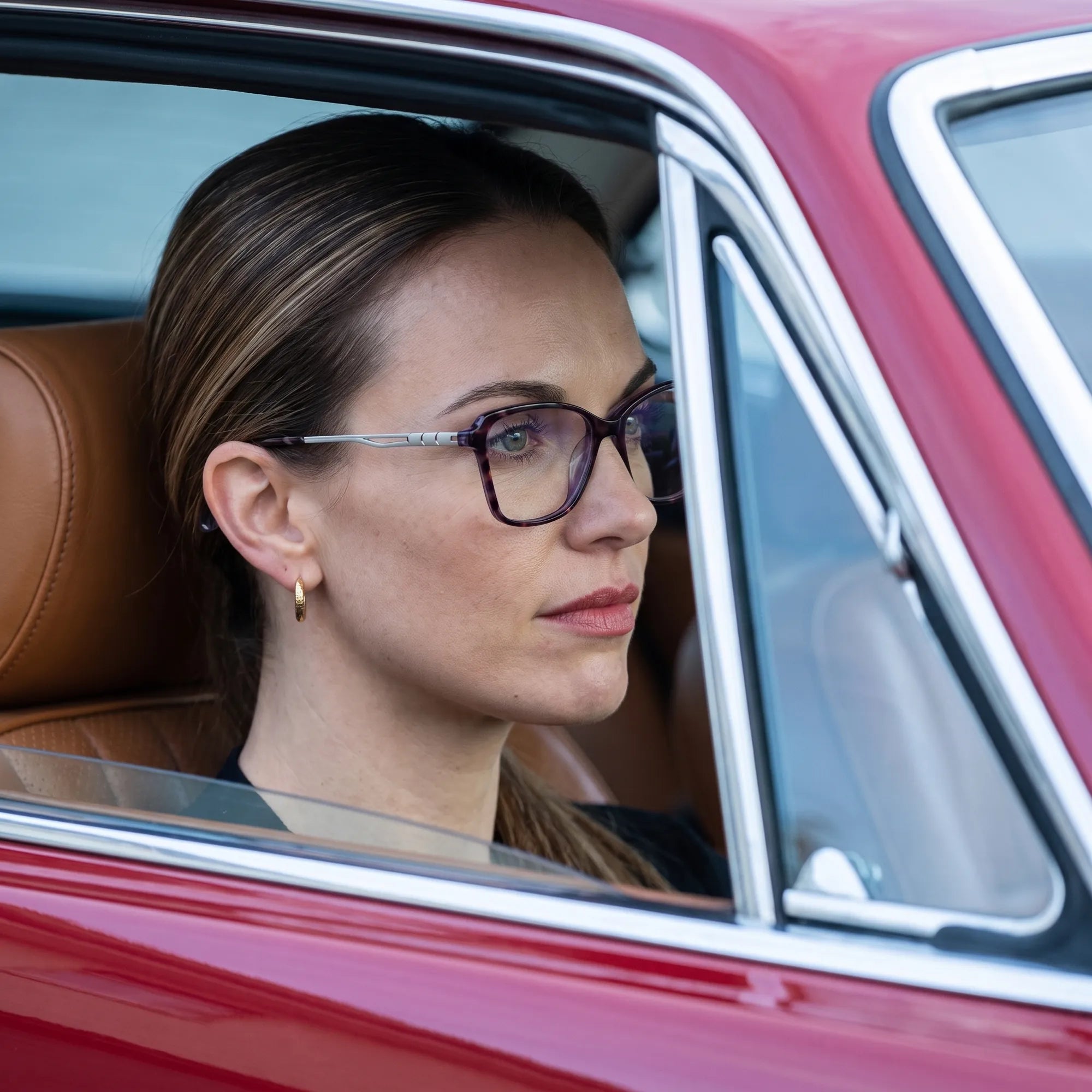 Anteojos Fiore 1006 en morado, en modelo – retrato de campaña, mirada a través de la ventana de un auto clásico rojo