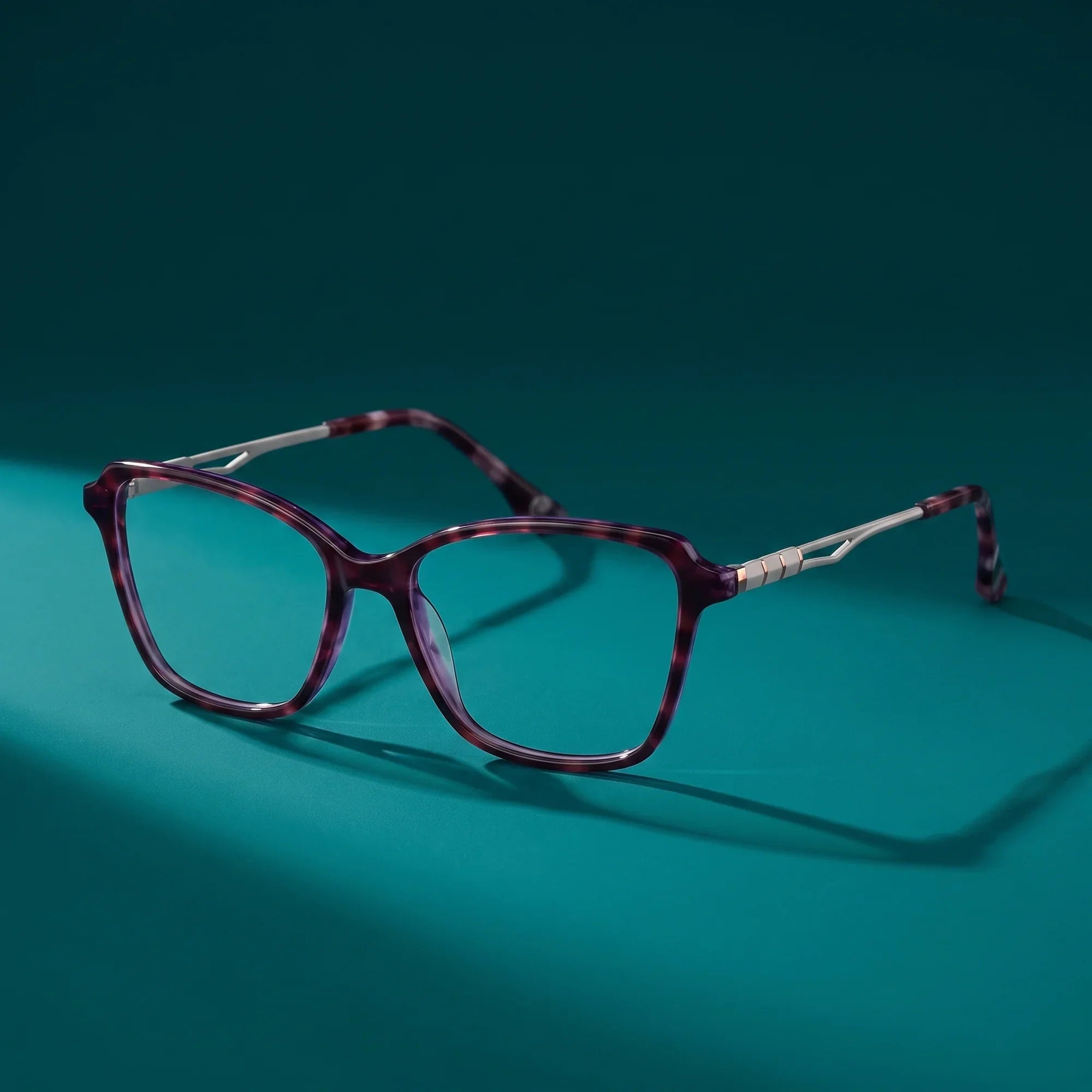 Anteojos Fiore 1006 en morado – still life on a seamless teal studio backdrop