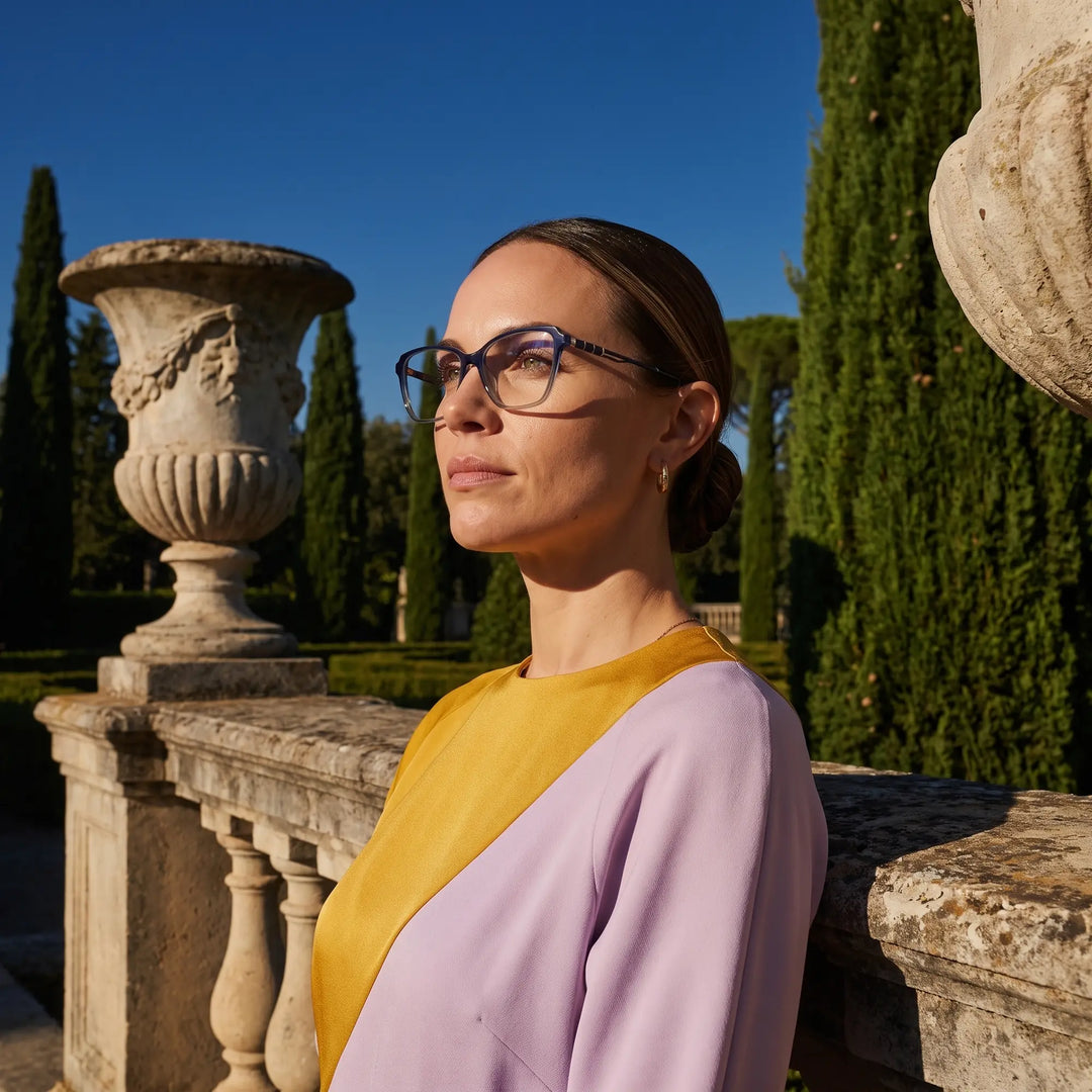 Anteojos Fiore 1006 en azul, en modelo – retrato de campaña, luz de atardecer sobre un jardín de cipreses