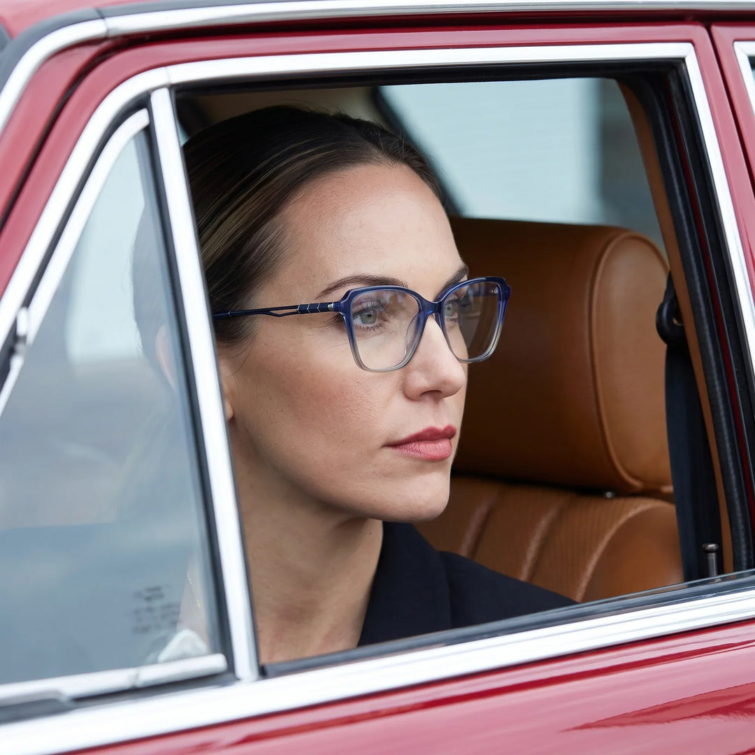 Anteojos Fiore 1006 en azul, en modelo – retrato de campaña, mirada a través de la ventana de un auto clásico rojo