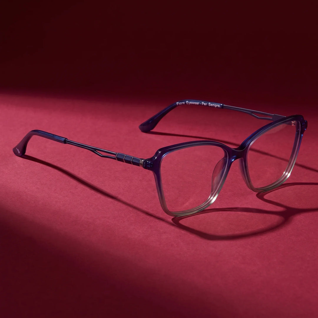 Anteojos Fiore 1006 en azul – editorial still life on a saturated burgundy set