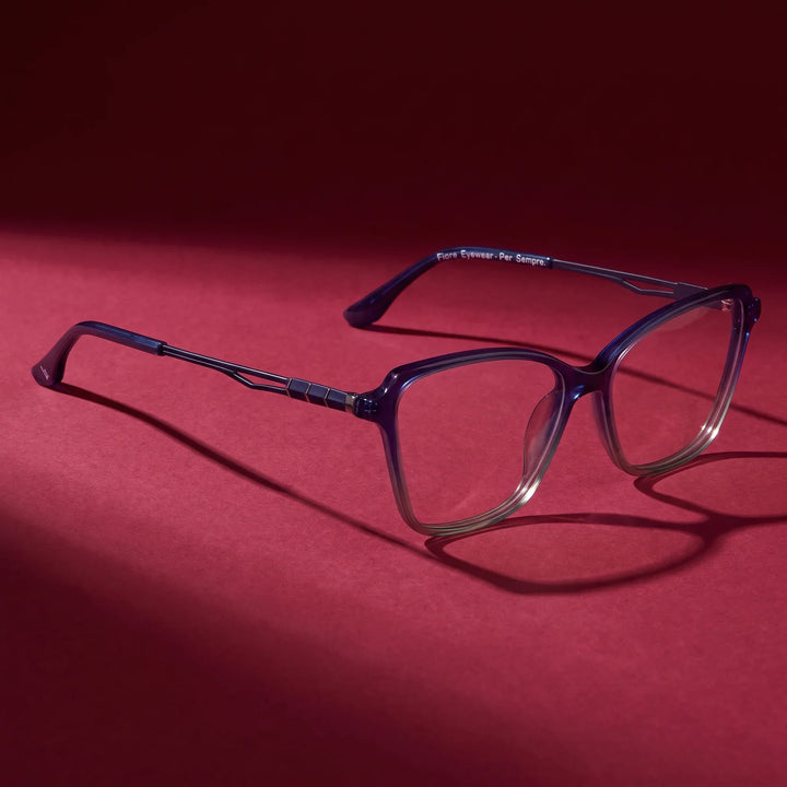 Anteojos Fiore 1006 en azul – editorial still life on a saturated burgundy set