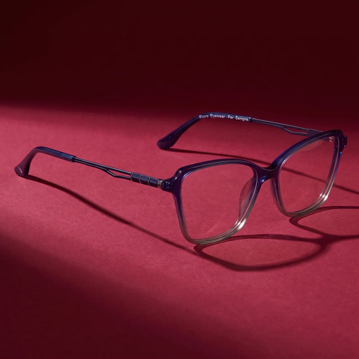 Anteojos Fiore 1006 en azul – editorial still life on a saturated burgundy set