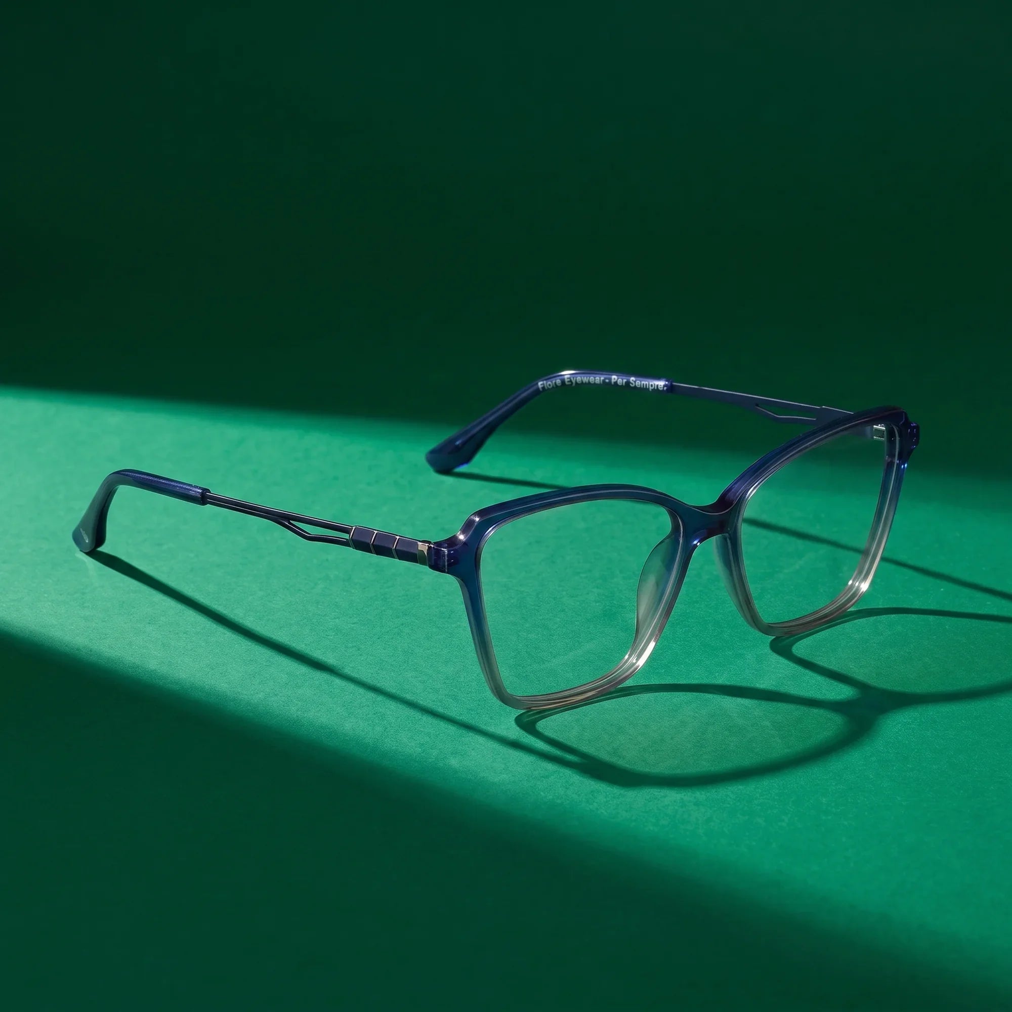 Anteojos Fiore 1006 en azul – still life on a seamless emerald studio backdrop
