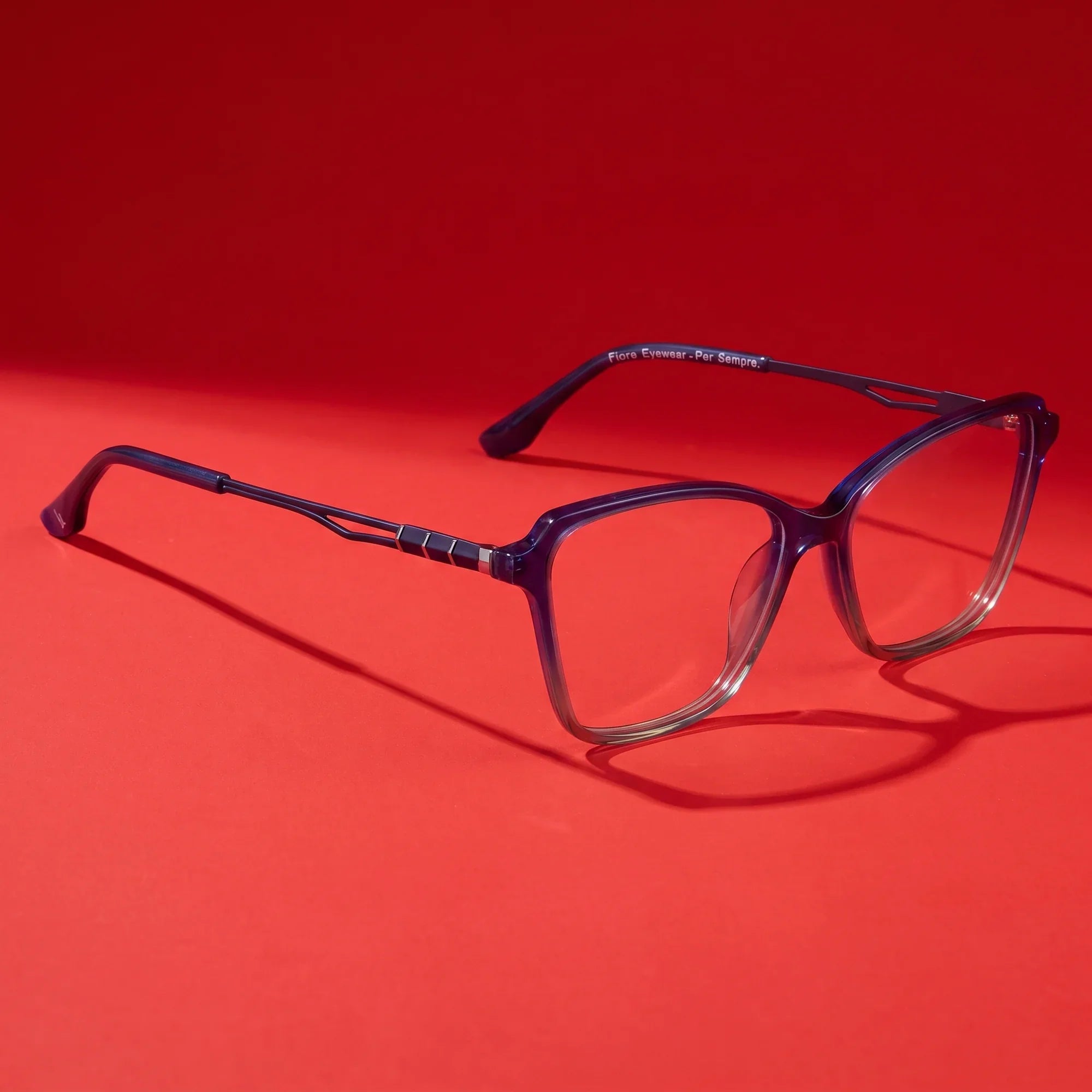 Anteojos Fiore 1006 en azul – hero still life against a deep vivid red backdrop