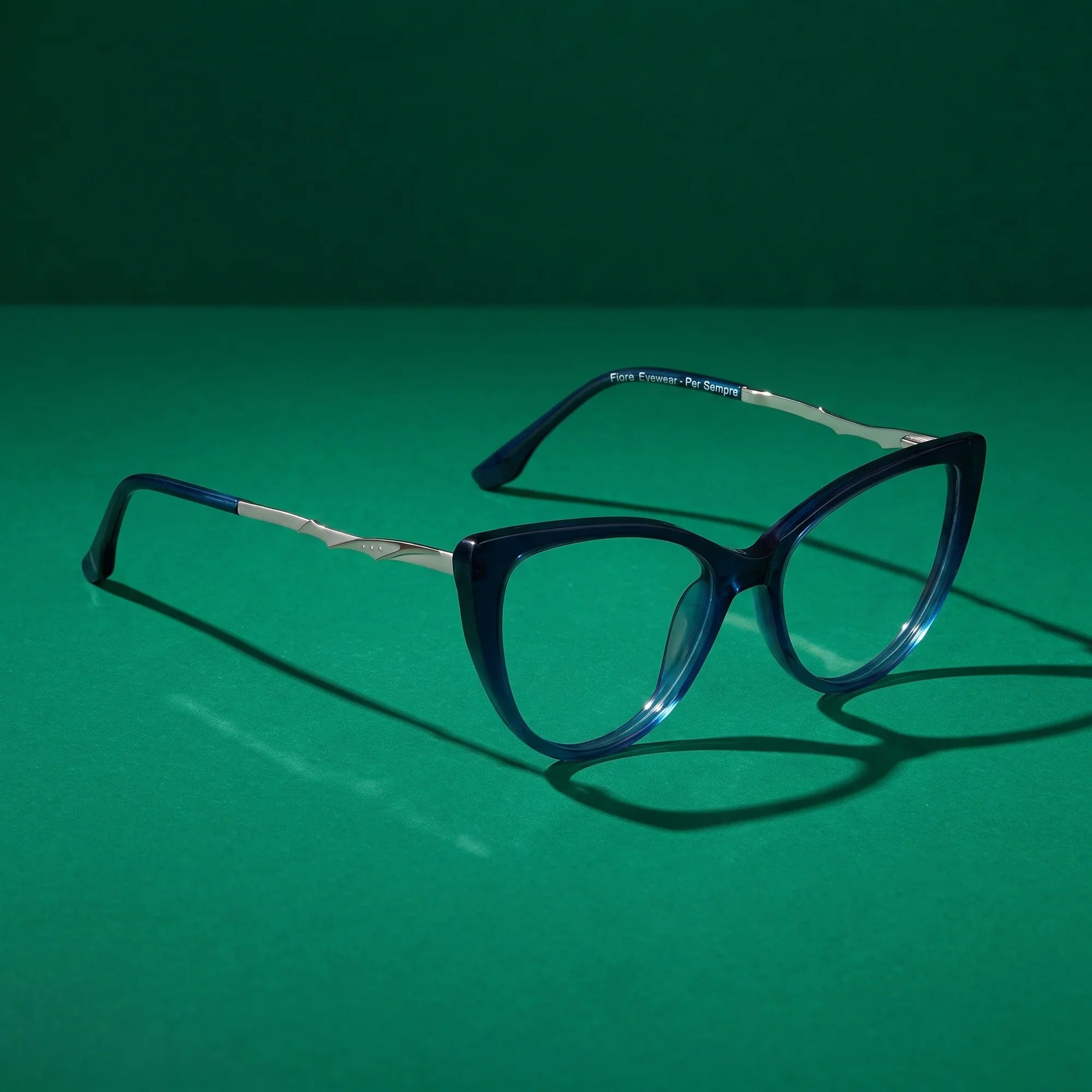 Anteojos Fiore 1010 en azul – still life on a seamless emerald studio backdrop